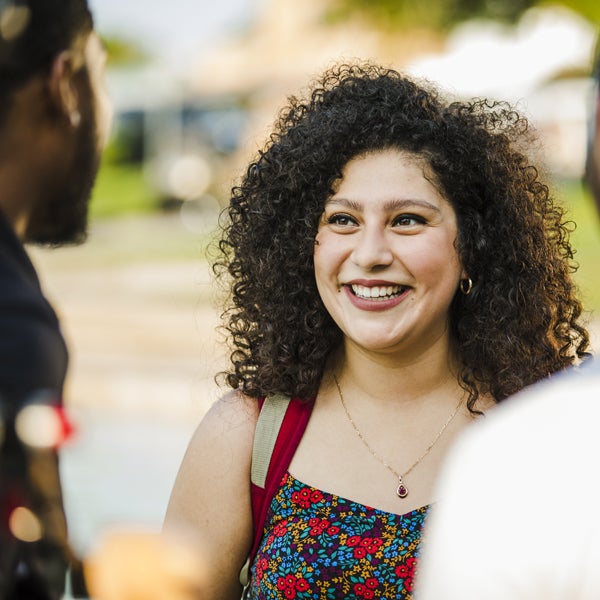 female ucf student smiling while talking to a male student off camera to hte left