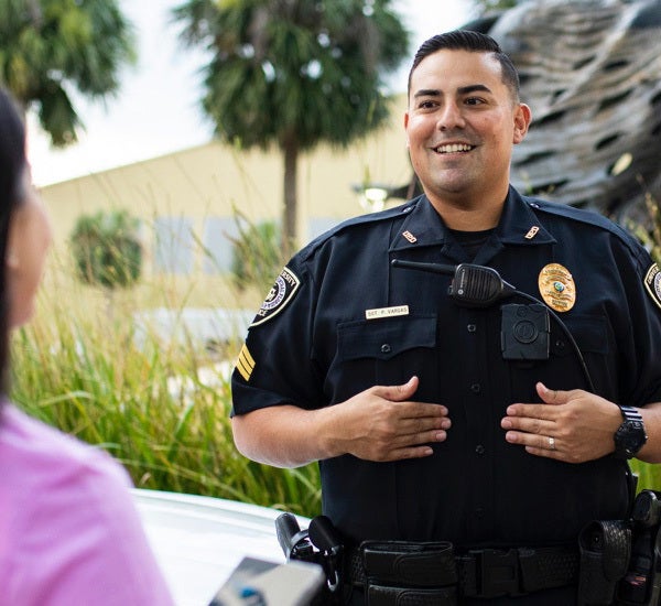 ucf police officer holding his hands on his mid-section, talking to person off camera to the left