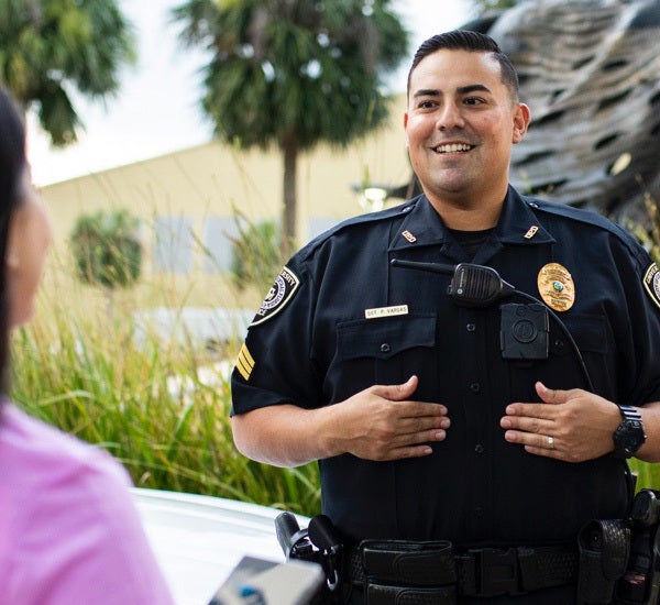 male ucf police officer holding his hands on his mid-section, talking to female off camera to the left