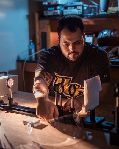 male student wearing ucf shirt working in a lab