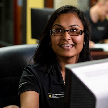 ucf undergraduate admissions employee smiling while helping someone off camera