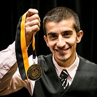 Burnett Honors College Student holding honors medallion