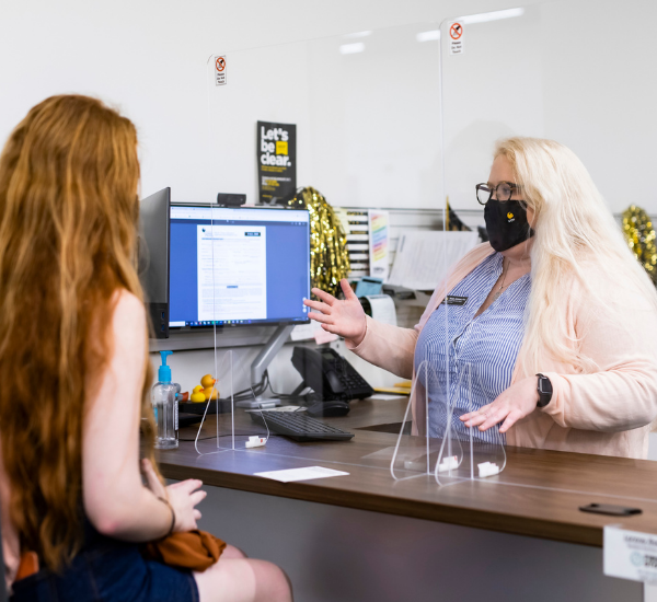 A student speaks with an advisor at a desk inside the UCF Downtown First Stop