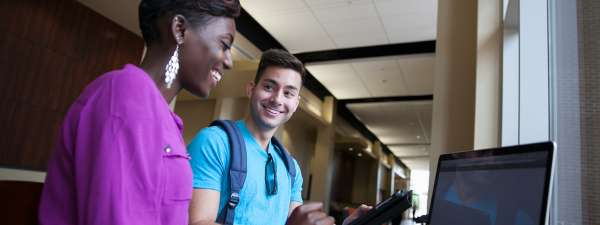 two students looking at laptop