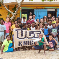 ucf students studying abroad surrounded by children