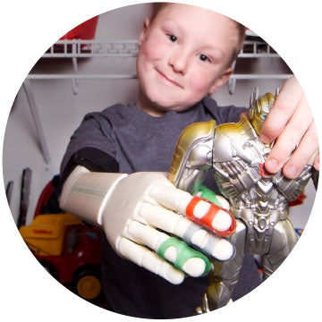 little boy playing with robot with 3d printed arm from limbitless