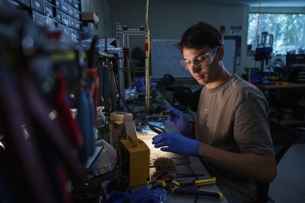 A student is soldering electrical components in one of UCF's labs.