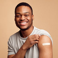 student showing arm with Band-Aid after getting COVID-19 vaccine