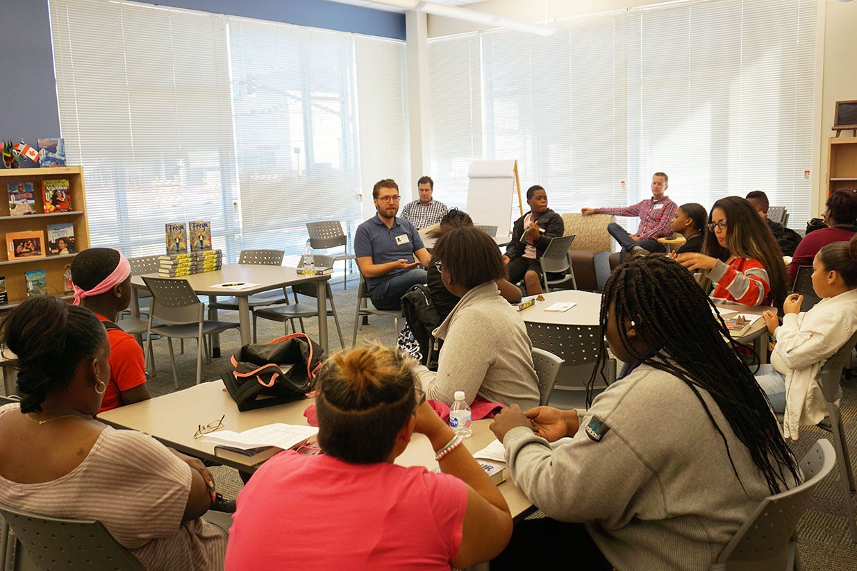 Laurence sits with AC book club students.