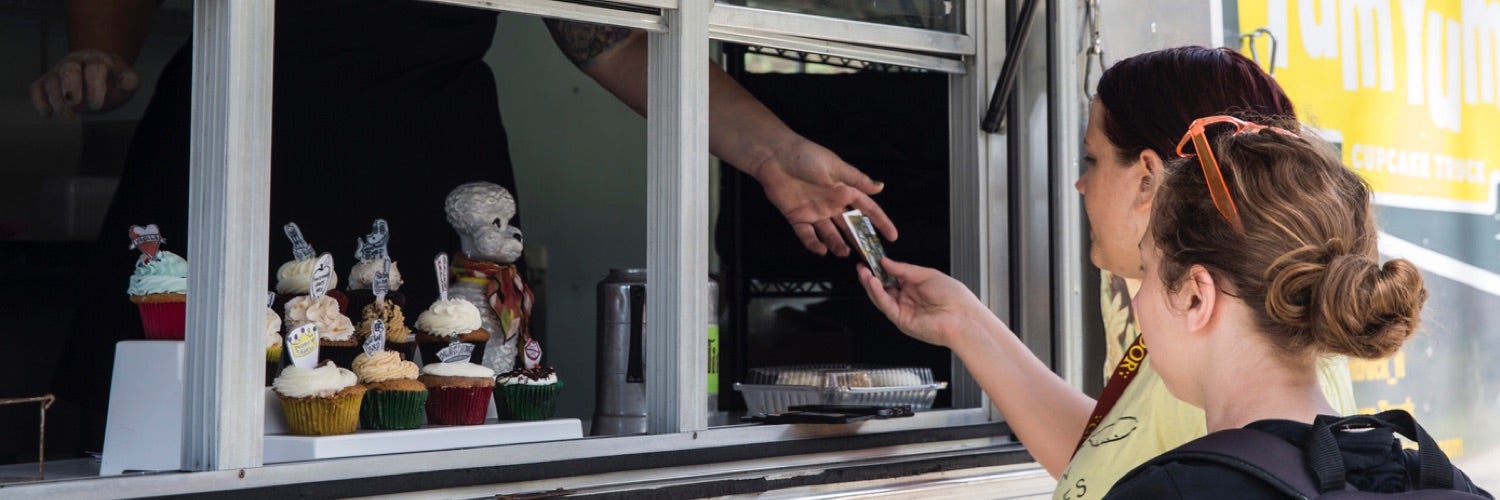 Two college students paying for an item at a food truck.