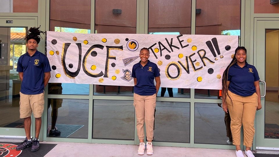 students in front of banner