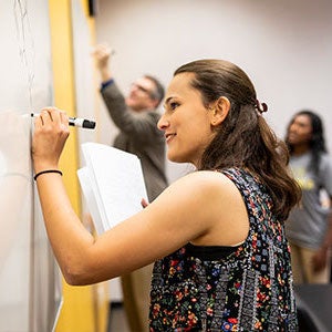 Student writes on whiteboard.