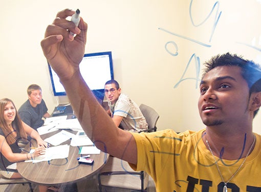 Student writes on a board.