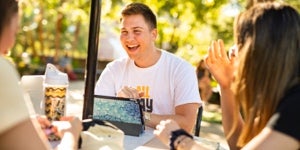 smiling students sitting at a table outside