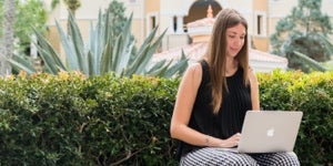 student sitting outside with laptop