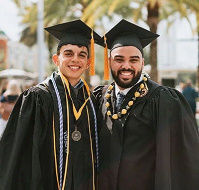 Two student in graduate gowns