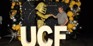 Knightro and employee fist bumping at the employee celebration