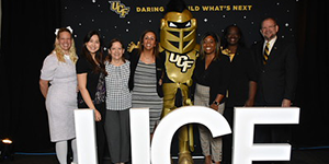 Knightro and President Cartwright posing with employee awardees on Founders Day.