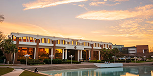 Millican Hall with a sunset in the background.