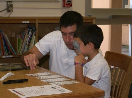 Cocoa nursing student Alan Bowers performs a vision test at Coquina Elementary School in Titusville. Bowers is in his third semester of nursing school at UCF and a former Army Medic.