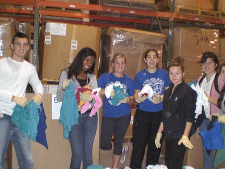 Students sort and package items at the Harvest Time International warehouse.