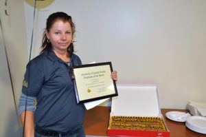Josefina Aleman holding her certificate of USPS Employee of the Month for February