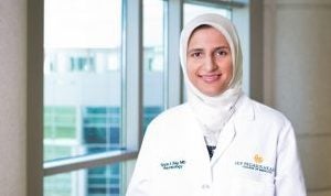 smiling woman wearing white ucf lab coat