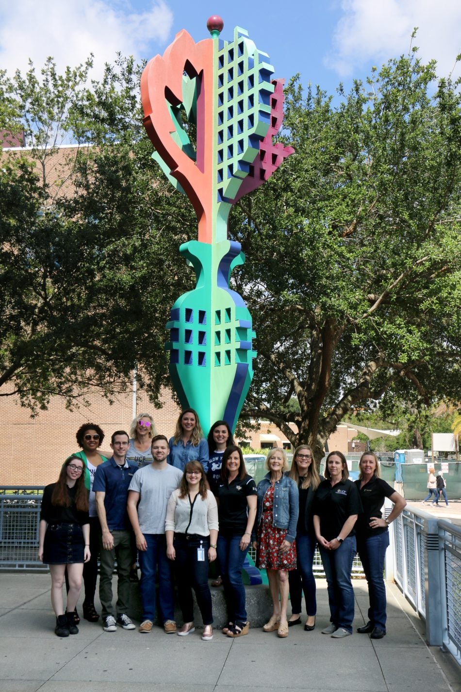 group of ucf staff From the College of Sciences in front of an abstract colorful statue
