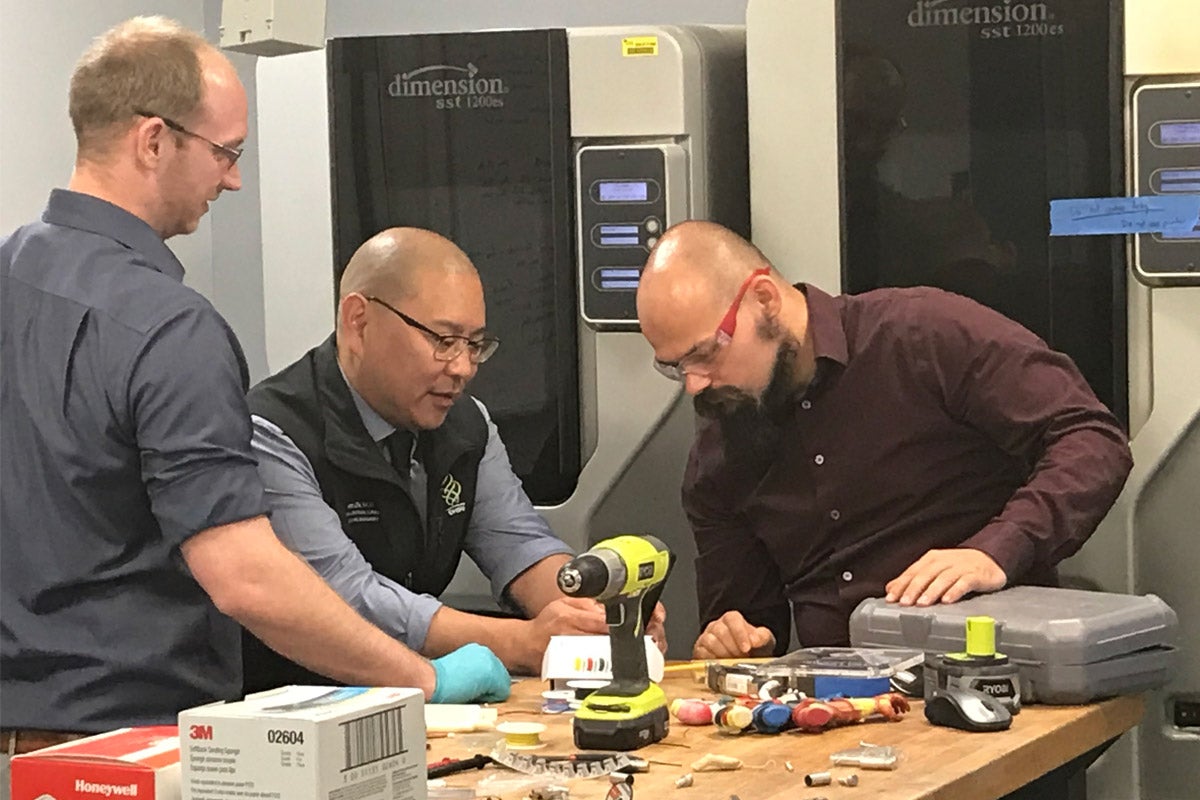 Albert Chi (center), associate professor of surgery in the OHSU School of Medicine, works with John Sparkman, director of research and development for Limbitless Solutions, and Dominique Courbin, director of production.