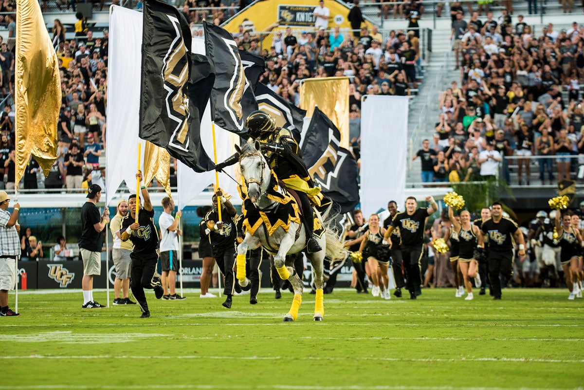 Photo of UCF cheer and Pegasus charging the field