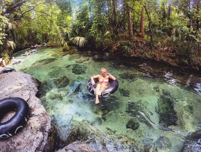 woman in bathing suit floating on tube down Kelly Park/Rock Springs Run