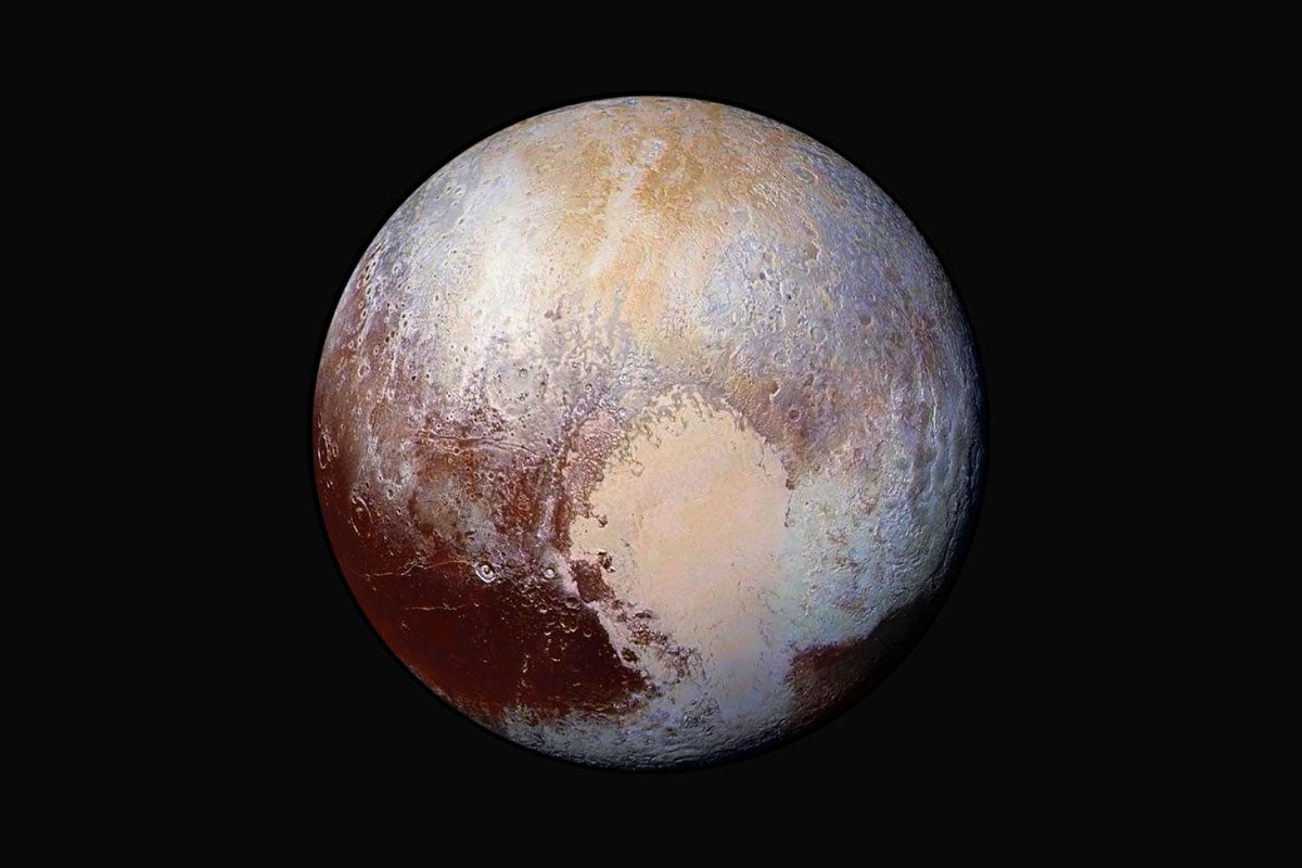 Pluto in space, with brown, beige and hints of blue coloring in the sphere
