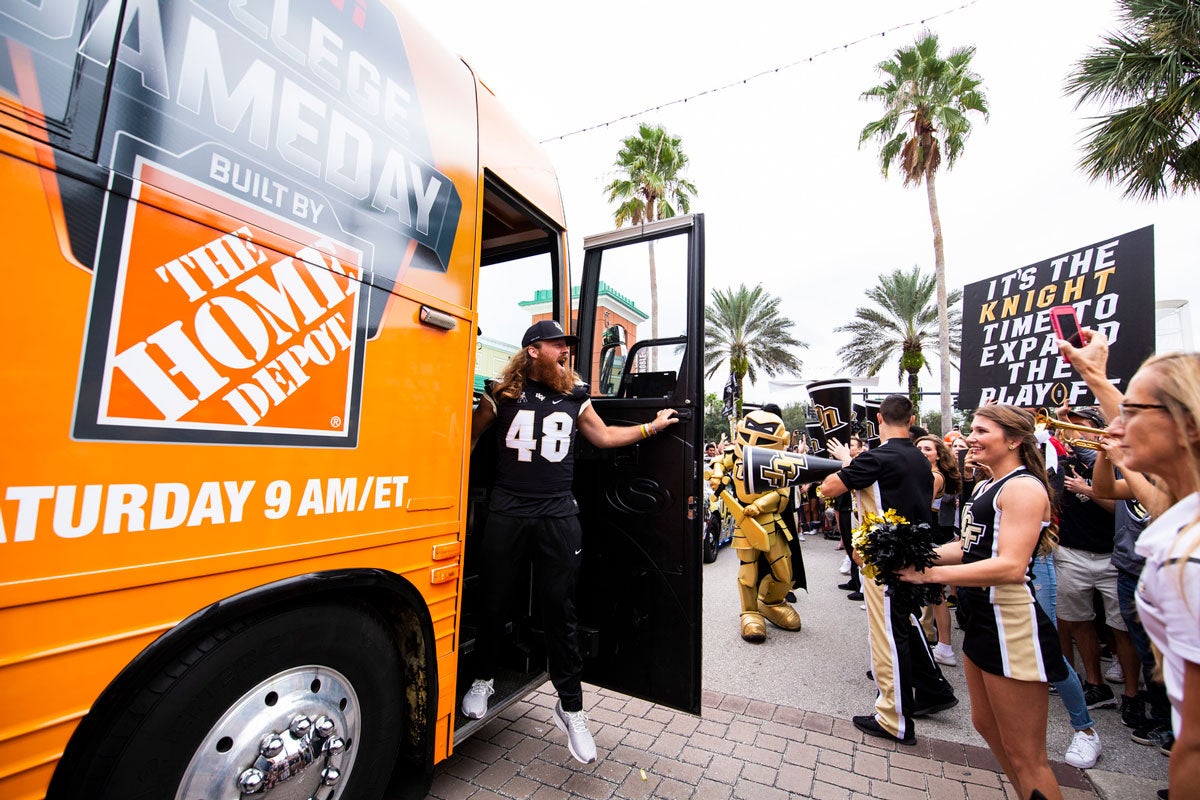 UCF Football player Mac Loudermilk wearing his #48 jersey steps off Orange bus with Home Depot logo and greets cheering fans