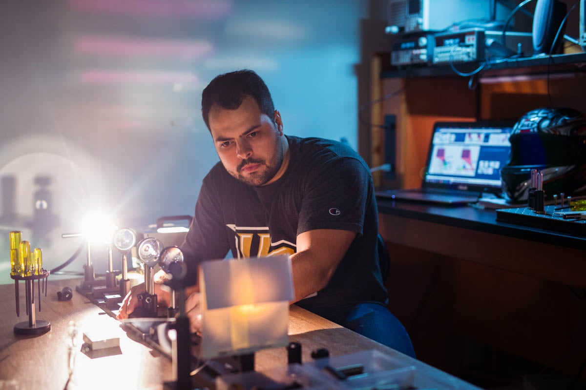 While in a lab, a student works on a project involving display screens and motorcycle helmets.