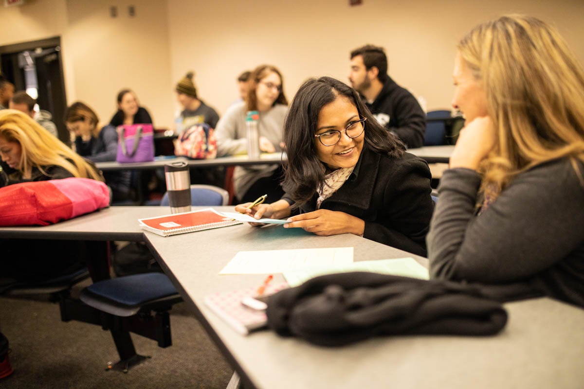 Students work together in pairs to negotiate a deal during a class. (Photo by Austin Warren)