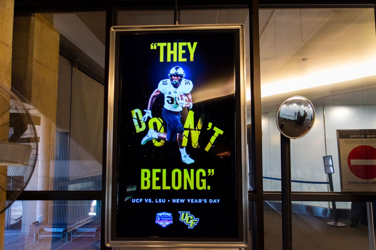 sign that reads "they don't belong" as a player breaks through the word "don't"