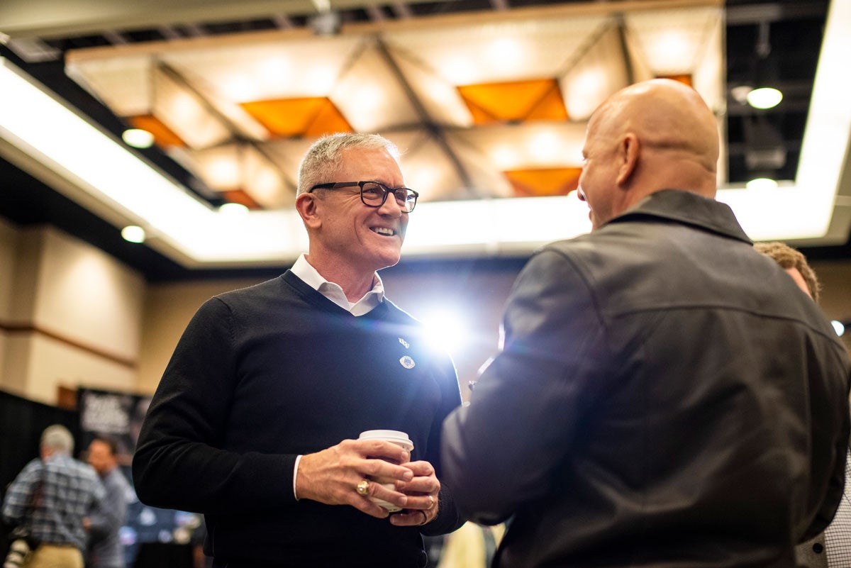 Two men talk in a hotel ballroom