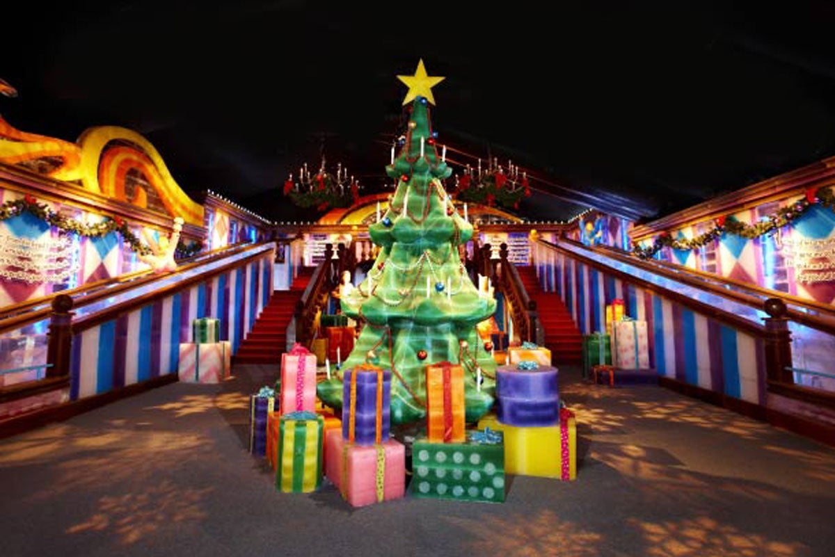 A green Christmas tree with a yellow star on top is surrounded by colorful presents, all made out of ice blocks