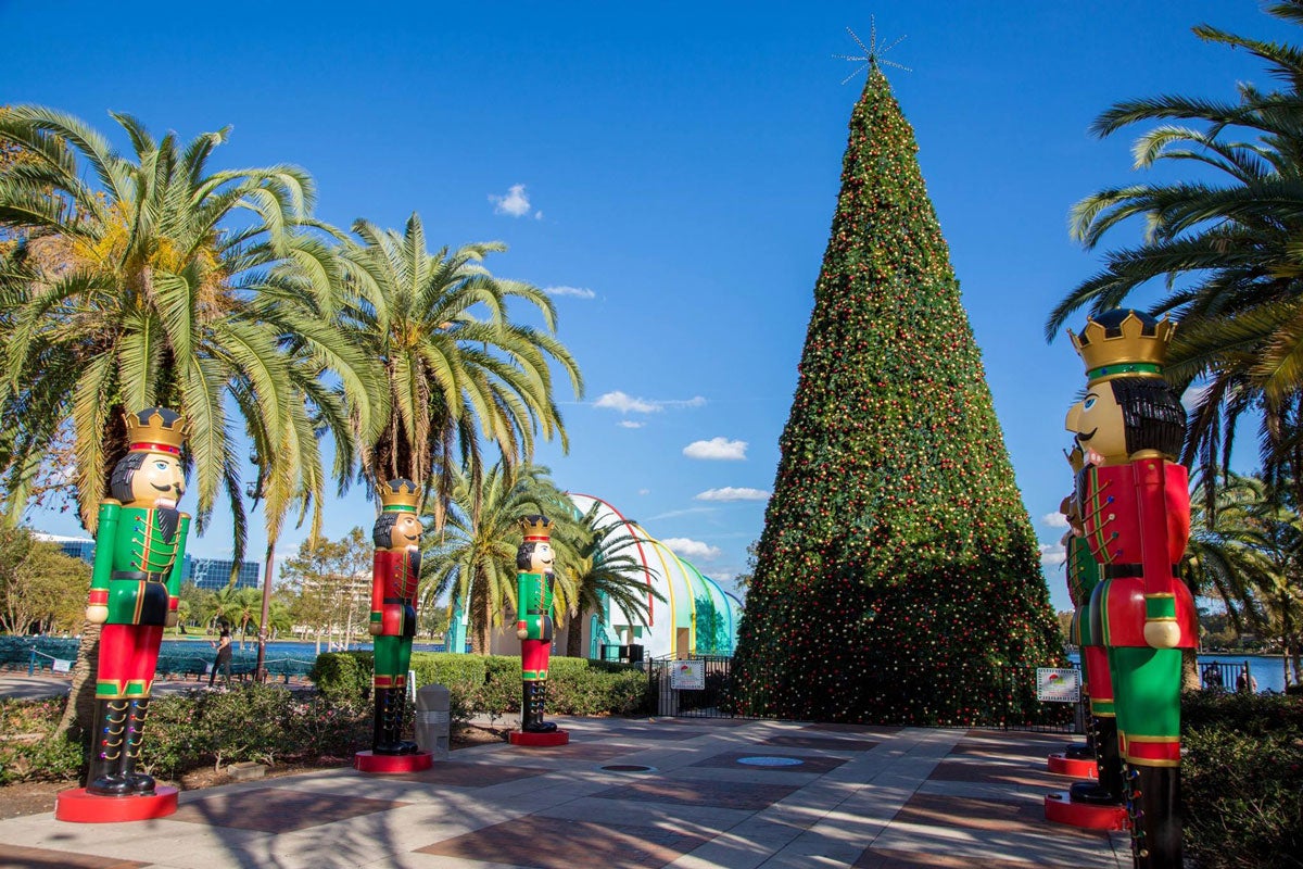 A giant Christmas tree is at the end of a path lined with red and green Nutcracker statues