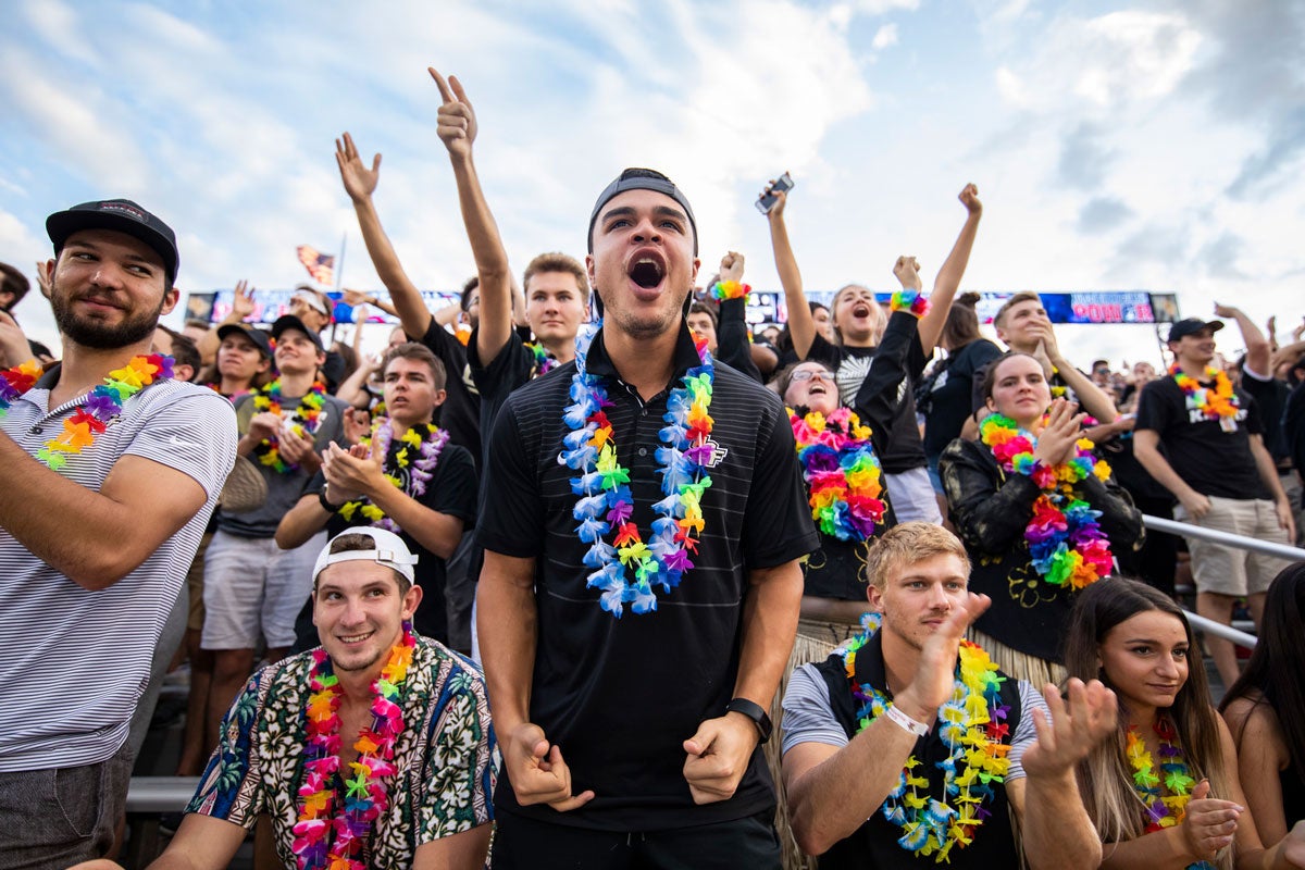 UCF fans cheer while wearing colorful leis