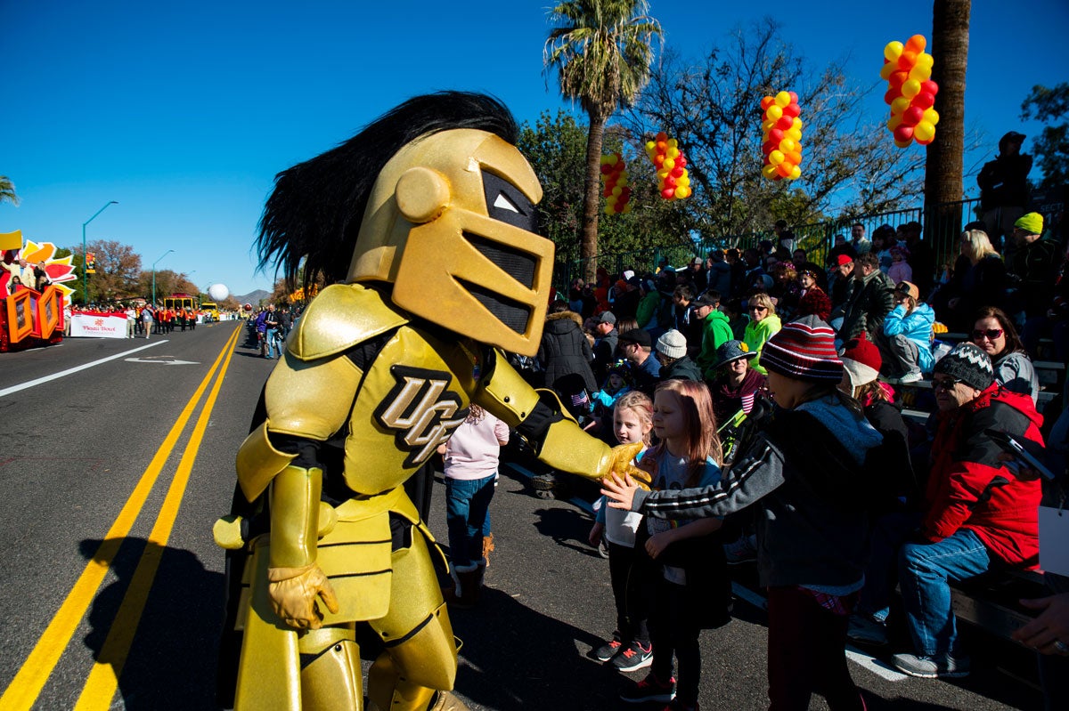 UCF mascot Knightro shakes hands with children.