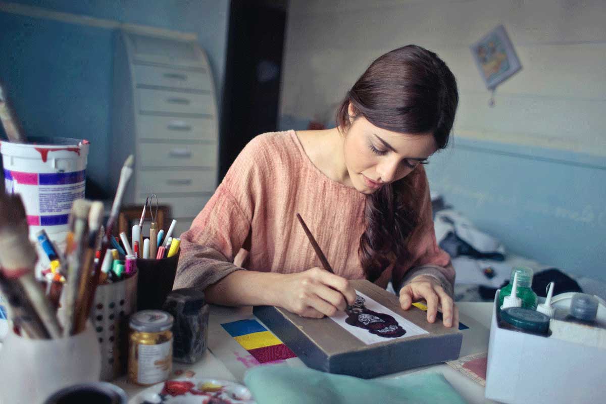 Brunette girl paints at a table