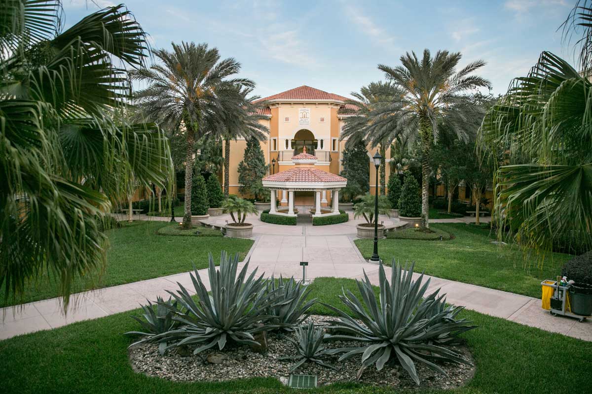 Resort-style building with a gazebo among palm trees