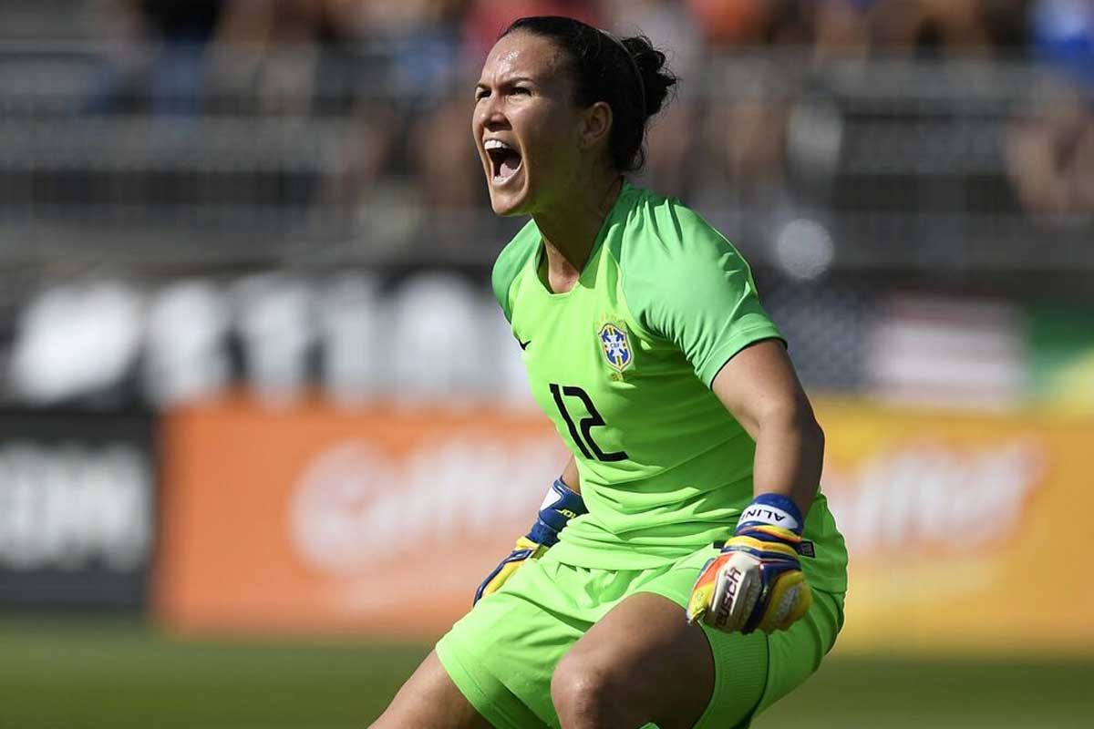 Female goalkeeper in green uniform yells