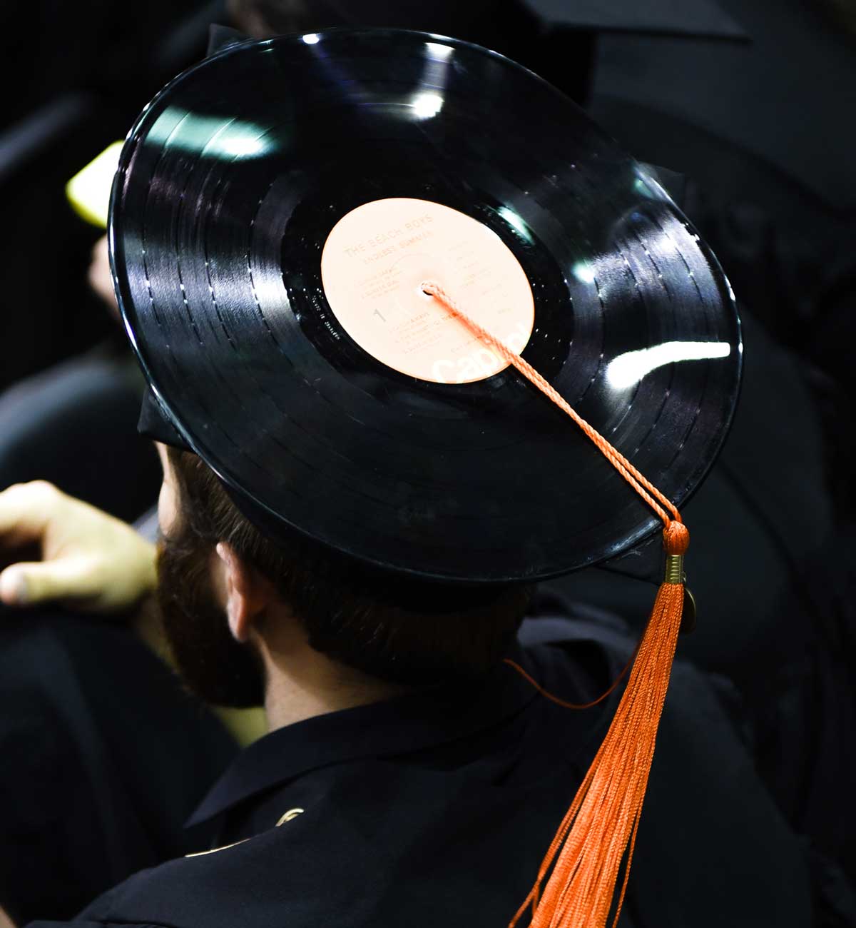 Grad cap decorated with vinyl record and orange tassel