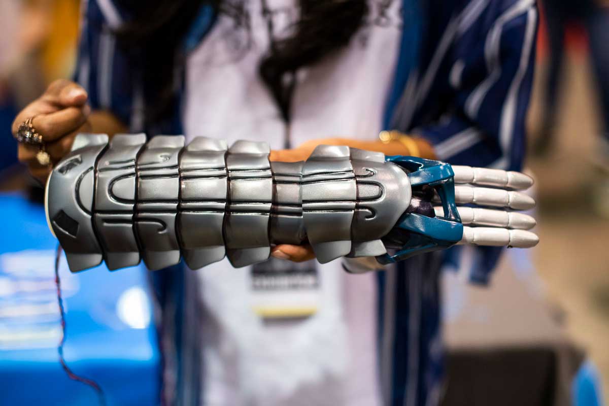 Woman holds gray prosthetic arm 