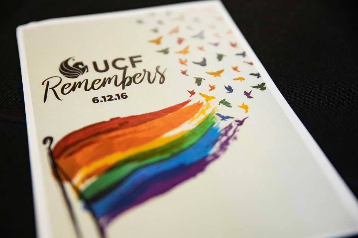 white paper with rainbow flag that reads "UCF Remembers 6.12.16"