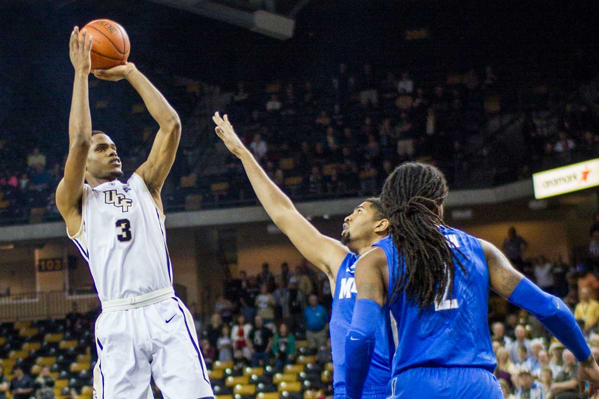 UCF basketball player AJ Davis pulls up for a jumper with defender coming at him