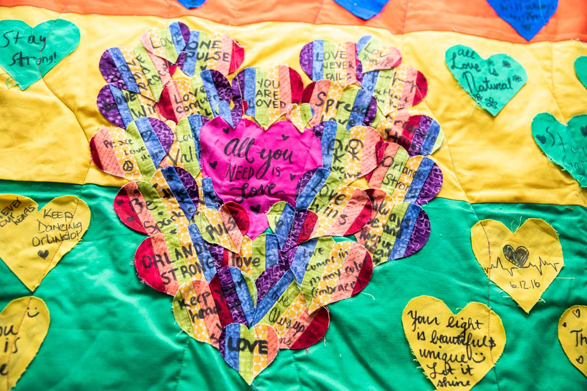 multi color quilt with a heart stitched in the center