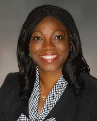 African-American woman in black blazer and black and white shirt 